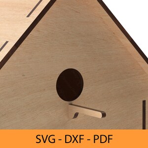 May include: A wooden birdhouse with a round entrance hole and a small perch. The birdhouse is made of light brown wood with dark brown trim.