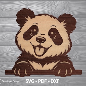 Op de afbeelding: Houten panda beer uitgesneden met een lachend gezicht en tong uitgestoken. De panda heeft donkerbruine accenten rond de ogen, oren en poten. De tekst "Teunique Design SVG - PDF - DXF" staat onderaan.