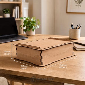 May include: A light-coloured wooden box with a lid, measuring 266mm long, 214mm wide, and 89mm high. The box has a rectangular shape with a decorative design and is suitable for storage.