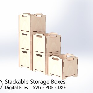 Puede incluir: Tres cajas de almacenamiento de madera con asas, apiladas una encima de la otra. Las cajas son de madera clara y tienen un acabado natural. Las cajas est&aacute;n etiquetadas como "Cajas de almacenamiento apilables" y "Archivos digitales SVG - PDF - DXF".