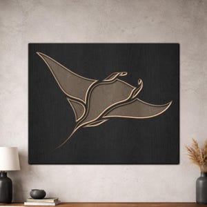 Op de afbeelding: Houten wandkunst met een gestileerd manta rog ontwerp. Het kunstwerk toont een donkere achtergrond en een lichtere, natuurlijk houten manta rog silhouet. Het ontwerp is een moderne, minimalistische weergave van het zeeleven.