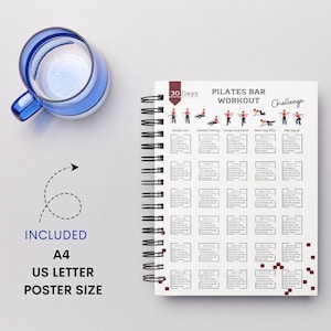 May include: A white 30-day Pilates Bar Workout Challenge journal with a black spiral binding. The cover features a red and white design with illustrations of different exercises. The text on the cover reads "30 Days Pilates Bar Workout Challenge".