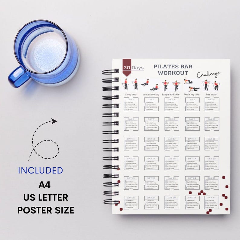 May include: A white 30-day Pilates Bar Workout Challenge journal with a black spiral binding. The cover features a red and white design with illustrations of different exercises. The text on the cover reads "30 Days Pilates Bar Workout Challenge".