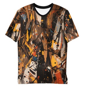 Peut inclure: Un t-shirt à manches courtes arborant un motif abstrait de projections de peinture sur toute la surface. Le design se compose de coulures et d'éclaboussures superposées en noir, marron, jaune ocre, blanc, avec des touches d'orange et de bleu.