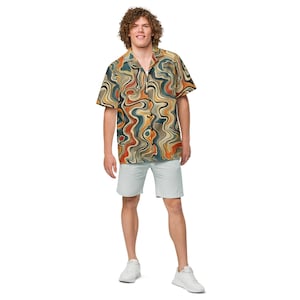 May include: A short-sleeved button-down shirt with a swirling abstract pattern in shades of orange, brown, blue, and beige. The shirt is paired with light blue shorts and white sneakers. The outfit is casual and stylish.