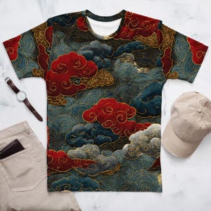 May include: A short-sleeved t-shirt with a repeating pattern of red, blue, and gold stylized clouds on a dark teal background. The design is reminiscent of traditional Asian art. A watch, wallet, and baseball cap are also visible.