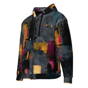 May include: A zip-up hoodie with an abstract design. The hoodie features a pattern of overlapping rectangles in shades of gray, black, yellow, and magenta. It has a hood, a front pocket, and a black zipper.