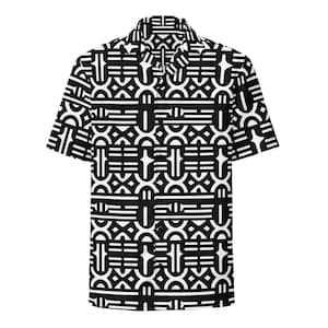 May include: A short-sleeve button-down shirt featuring a repeating black and white geometric pattern. The design consists of interconnected lines, arches, and horizontal bars across the entire garment, including the collar and short sleeves.