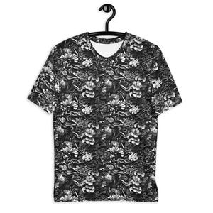 May include: A short-sleeve t-shirt featuring an all-over black and white graphic print. The pattern consists of detailed floral motifs, stylized blossoms, and swirling wave-like elements covering the entire fabric of the garment.