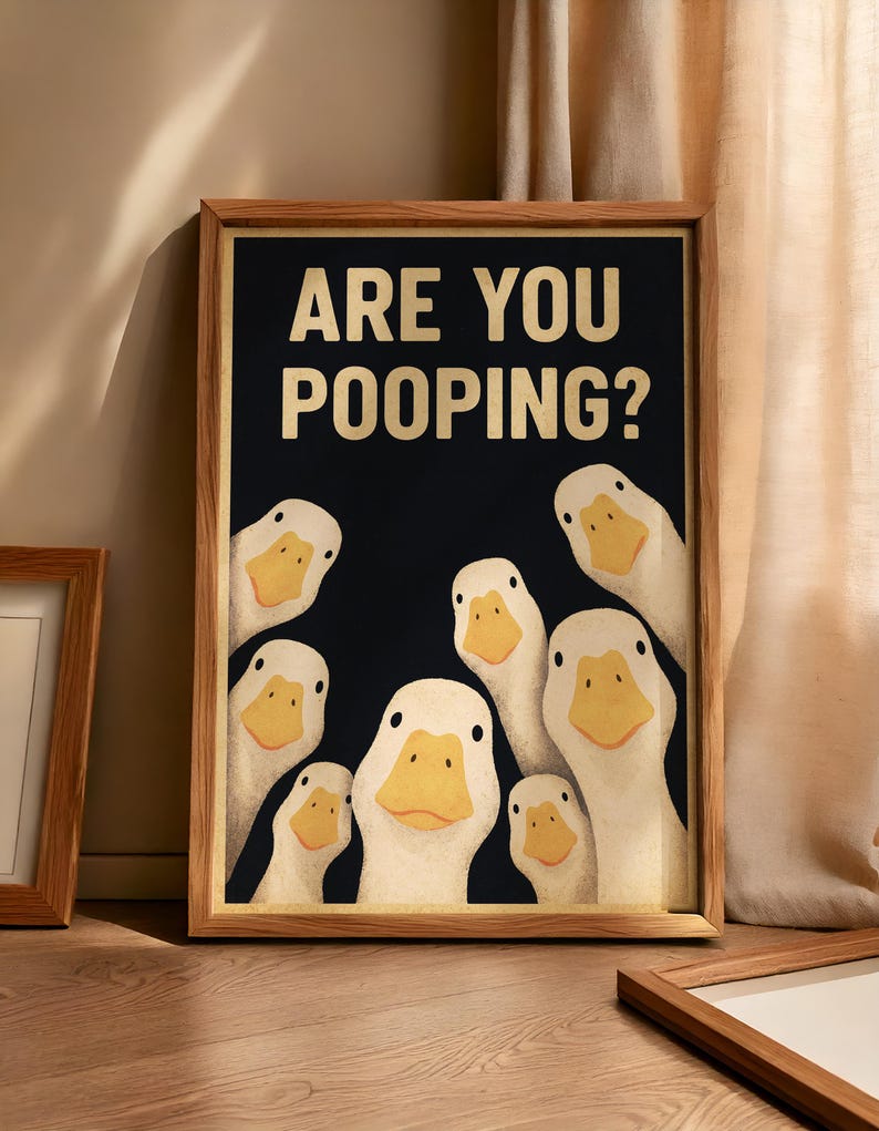 a framed poster with a humorous cartoon duck illustration, displaying the text "ARE YOU POOPING?"
