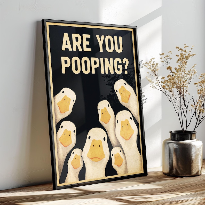 A framed poster with a cartoon image of ducks and the text "ARE YOU POOPING?"