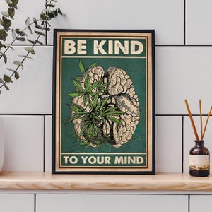 May include: Framed poster with the text "BE KIND TO YOUR MIND". The artwork features a detailed illustration of a brain with cannabis leaves and a green background. The poster is in a black frame.