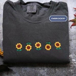 a t - shirt with embroidered sunflowers on it