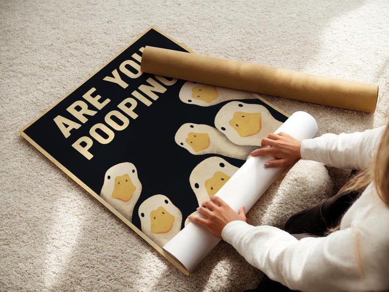 A person is rolling up a poster with a humorous message about ducks.