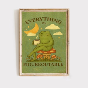 May include: A framed print featuring a cartoon frog sitting on a mushroom, holding a cup of coffee. The print has a green background with the words "EVERYTHING IS FIGUREOUTABLE" in a vintage style.