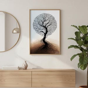 May include: A framed art print featuring a black and white tree design. The tree has a circular crown and detailed roots. The artwork is displayed on a white wall above a wooden cabinet, with a round mirror and a potted plant nearby.