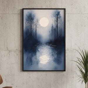 May include: A framed art print depicting a serene landscape. The artwork features a moonlit scene with a body of water reflecting the moon's light and silhouetted trees. The color palette is primarily shades of blue and white.