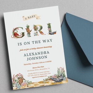 Puede incluir: Una invitación a una fiesta de bienvenida al bebé con un diseño de temática oceánica azul y verde. La palabra "GIRL" está escrita en letras grandes con ilustraciones de criaturas marinas. El texto dice "A Baby Girl is on the Way, join us for a baby shower honoring Alexandra Johnson, Saturday, October 12th at 2:00PM, Barca Pier Club, 123 Ocean Drive, Alexandria, VA, Kindly RSVP to Laura Johnson, 555-555-5555 by September 21st, registered at babylist.com".