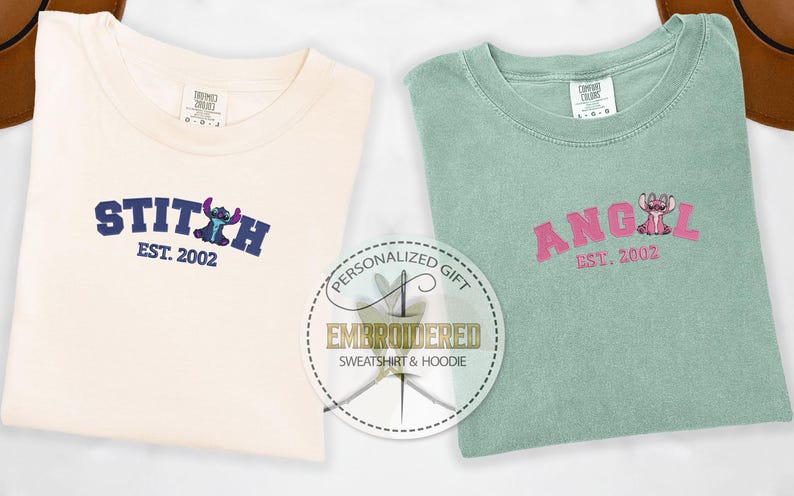 Puede incluir: Dos camisetas bordadas con un dise&ntilde;o de personaje de Stitch. La primera camiseta es crema con bordado azul y el texto "STITCH EST. 2002". La segunda camiseta es verde claro con bordado rosa y el texto "ANGEL EST. 2002".