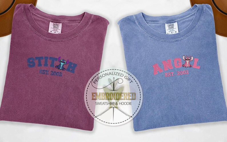 Puede incluir: Dos camisetas bordadas, una granate y otra azul, con el texto "STITCH EST. 2002" y "ANGEL EST. 2002" en una fuente de estilo universitario. Cada camiseta presenta un personaje de dibujos animados de la pel&iacute;cula de Disney Lilo & Stitch.