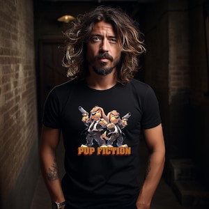 May include: A black t-shirt with a graphic of two cartoon dogs wearing suits and holding guns. The text "PUP FICTION" is printed below the dogs.