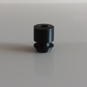 May include: A black rubber furniture leg with a threaded top and a rounded bottom.