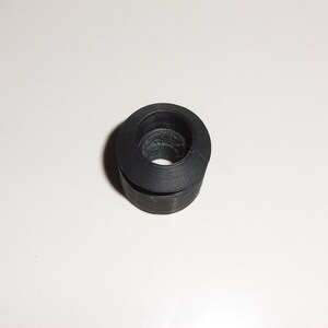 May include: Black rubber grommet with a round hole in the center.