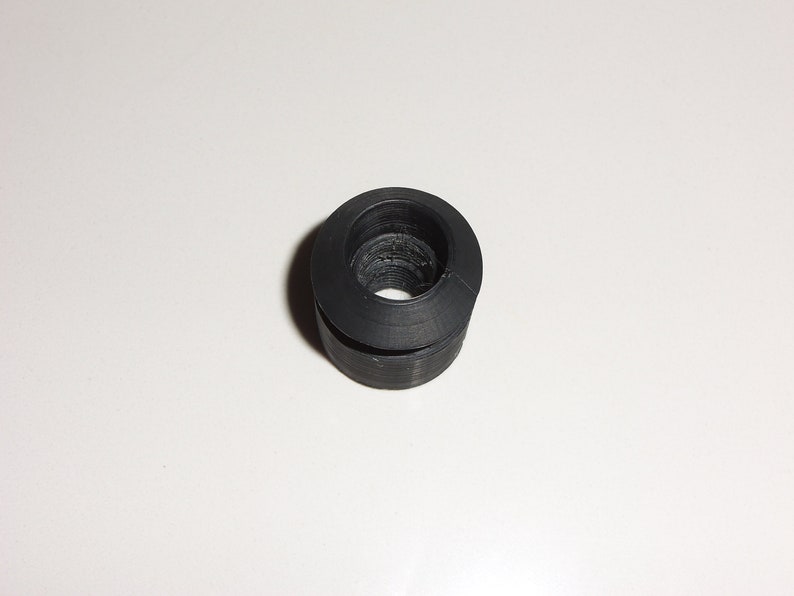 May include: Black rubber grommet with a round hole in the center.
