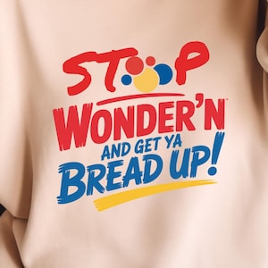 May include: A beige sweatshirt with the text "STOP Wonder'n AND GET YA BREAD UP!" in red, blue, yellow, and white. The sweatshirt has long sleeves and a crew neck.
