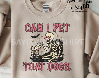 Puede incluir: Sudadera beige con el texto "CAN I PET THAT DOG?!" en rosa y negro. El gráfico presenta un esqueleto con gafas en forma de corazón acariciando a un perro. Un gráfico de murciélago está encima del texto. Las palabras "DIGITAL DOWNLOAD - 300 DPI - PNG FILE" están en la parte inferior.