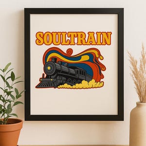 May include: A framed print featuring a retro-style illustration of a black steam train with the word "SOULTRAIN" in orange letters. The train is set against a colorful backdrop of red, yellow, and blue swirls, evoking a vintage aesthetic.