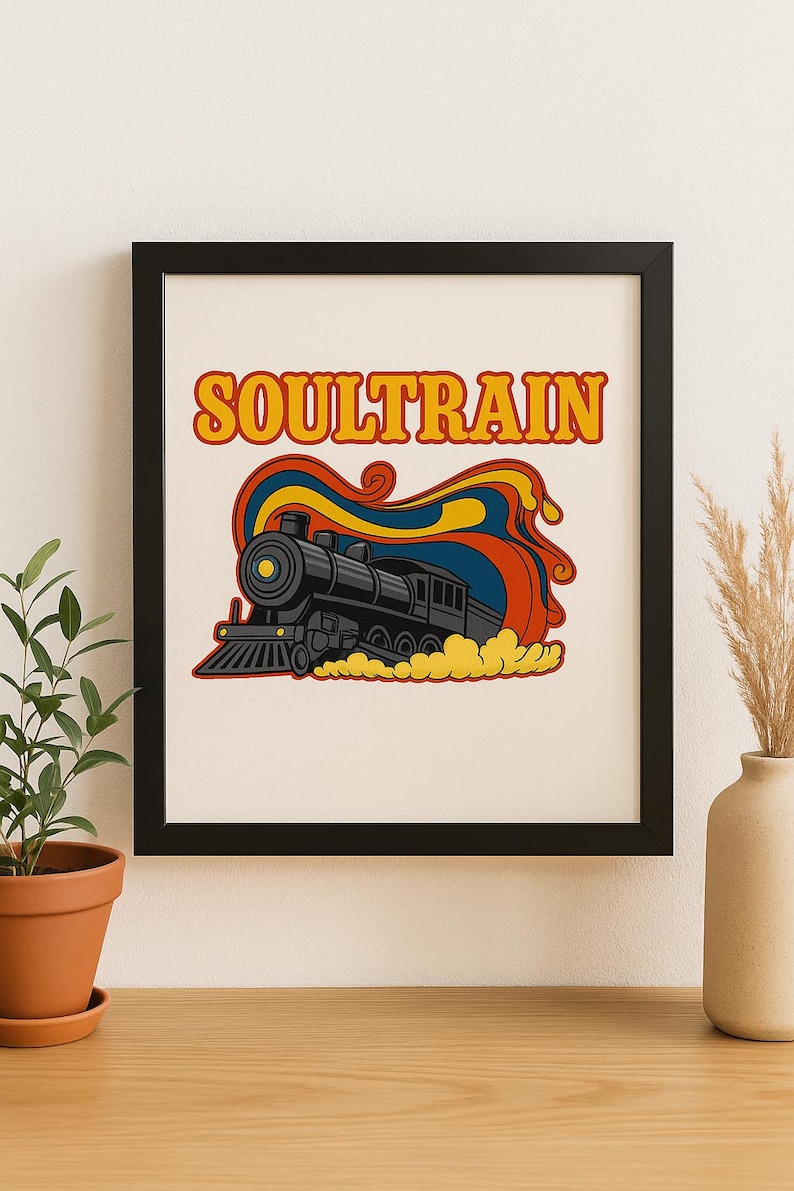 May include: A framed print featuring a retro-style illustration of a black steam train with the word "SOULTRAIN" in orange letters. The train is set against a colorful backdrop of red, yellow, and blue swirls, evoking a vintage aesthetic.