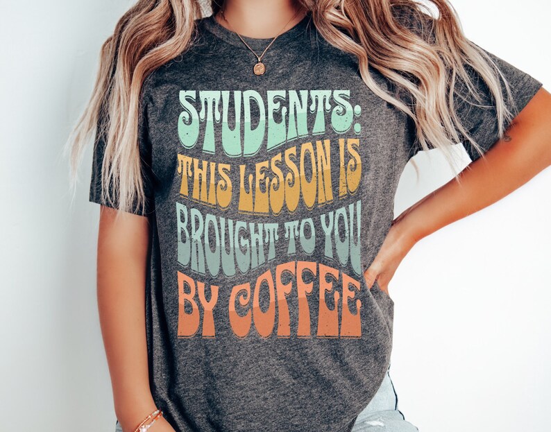 May include: A grey t-shirt with the text "Students: This lesson is brought to you by coffee" in a colourful retro font.