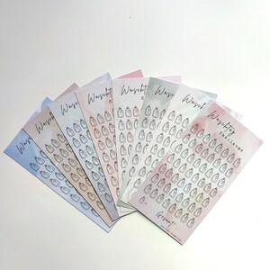 Könnte beinhalten: Ein Satz von acht bunten Karten mit Aquarellhintergrund. Jede Karte zeigt eine Schwarzweißillustration einer Flasche Waschmittel. Die Karten sind mit dem Text "Waschtag Challenge" und "Gesamt" beschriftet.