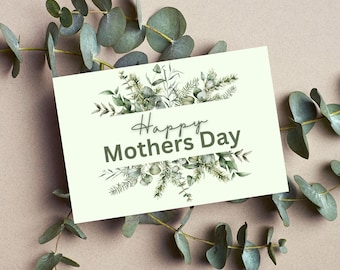 May include: A cream-colored greeting card with the text "Happy Mothers Day" in a script font, surrounded by watercolor greenery. Eucalyptus branches frame the card on a neutral background.