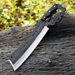 May include: A large, rectangular knife with a dark wooden handle and a wide, silver blade. The handle is dark brown with three small white rivets. The blade has a straight edge and a sharp point. The knife is lying on a weathered wooden surface.