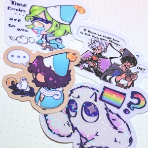 May include: A collection of colorful stickers featuring anime-style characters and speech bubbles. One sticker has the text "These Circles are so ass." Another says "I think we might have to kill this guy, Olrrugio."