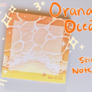 May include: Orange and white sticky notepad with a 7.6 cm x 7.6 cm design of an orange ocean with white foam. The notepad has the text "Orange Ocean Sticky Notepad" and the brand name "Kaiiiiichii" printed on it.