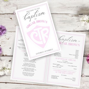Peut inclure: Invitation de baptême avec le texte "Welcome to the Baptism of Abigail Brown" en écriture élégante. L'invitation présente un code couleur rose et blanc, avec un monogramme et la date "Saturday, October 2".