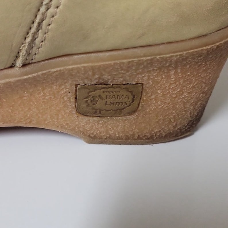 Pu&ograve; includere: Primo piano della suola di una scarpa in pelle beige chiaro con una suola in gomma marrone. La suola ha un'etichetta in pelle marrone con il testo "original BAMA Lams" in bianco.