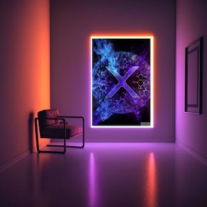 May include: A purple and blue abstract design with a white X in the centre, framed in a white frame with a light orange border. The artwork is hanging on a wall in a room with a chair.