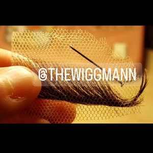 May include: A close-up of a brown hairpiece attached to a piece of netting with a needle going through it. The text "@THEWIGGMANN" is visible in the image.