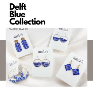 May include: Five pairs of blue and white Delft tile earrings on white cards with the text "Warner Clay Co.". The earrings are in various shapes, including circles, squares, and rectangles.