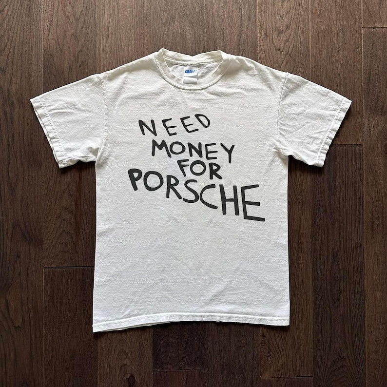 Puede incluir: Camiseta blanca con texto negro que dice "NEED MONEY FOR PORSCHE".