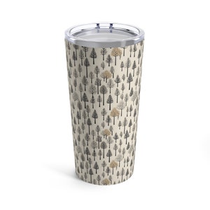 Op de afbeelding: Een roestvrijstalen tumbler met een crèmekleurige achtergrond en een herhalend patroon van zwarte en gouden bomen.