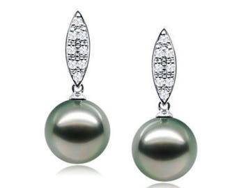 May include: A pair of elegant drop earrings featuring large, lustrous, dark gray pearls. Each earring has a silver-toned, leaf-shaped top adorned with small, sparkling clear stones. The earrings hang gracefully, showcasing the pearls' smooth, round shape.