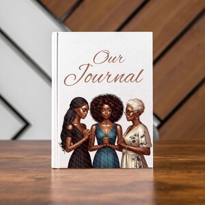 May include: A hardcover journal with the words "Our Journal" in elegant script. The cover features an illustration of three women with their hands clasped in prayer. The women are dressed in various gowns.