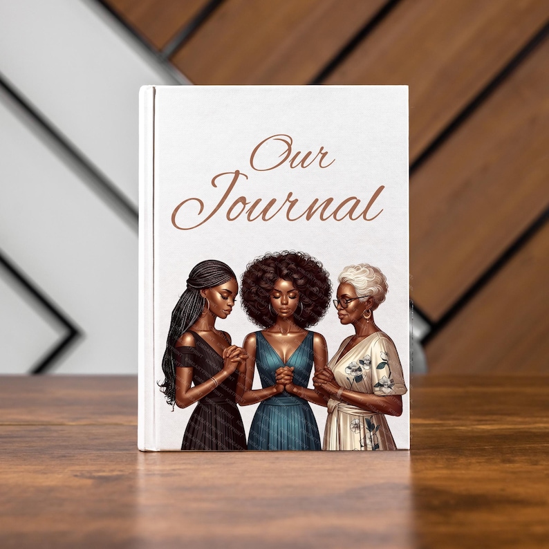 May include: A hardcover journal with the words "Our Journal" in elegant script. The cover features an illustration of three women with their hands clasped in prayer. The women are dressed in various gowns.