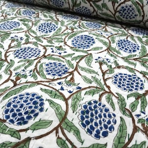 Può includere: Tessuto bianco con un motivo ripetuto di grappoli floreali blu, foglie verdi e steli marroni. Il disegno è stampato sul tessuto, creando un aspetto strutturato. Adatto per quilting o altri progetti tessili.