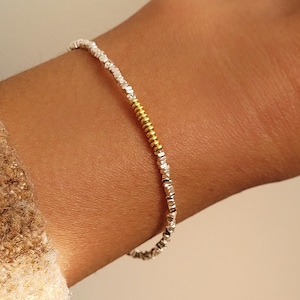 May include: A set of three ceramic mugs with a speckled, matte finish in cream, light grey, and dark grey. Each mug has a simple, minimalist design, suitable for coffee or tea.